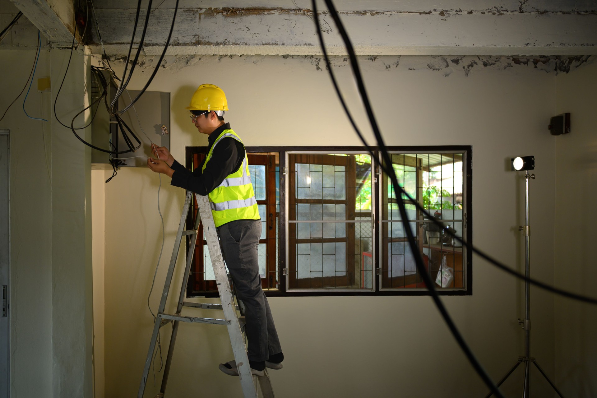 Construction supervisor inspecting electrical cables during a building renovation